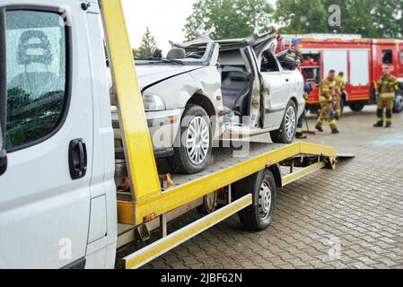 Zerstörte Autoverladung auf Abschleppwagen nach Unfall, Konzept des gefährlichen Fahrens nach Alkoholkonsum, Pannenhilfe Konzept Stockfoto