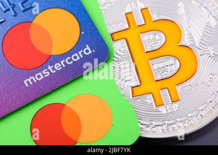 Krakau, Polen - April 29 2022: Mastercard Plastikkarten mit Bitcoin-Münze Stockfoto