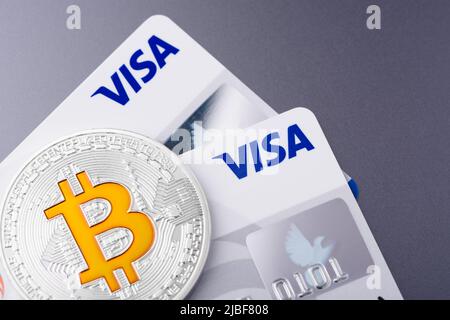 Krakau, Polen - April 29 2022: Visa Plastikkarten mit Bitcoin-Münze Stockfoto