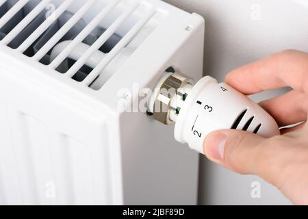 Manuelle Einstellung des Ventilknopfs des Heizkörpertemperaturthermostats in der kalten Wintersaison Stockfoto