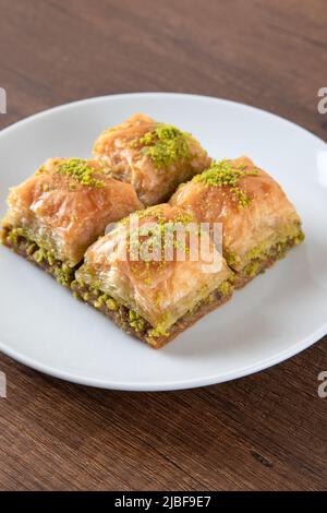 Traditionelle Pistazien Baklava in weißer Platte.Eine Platte Baklava auf Holzgrund Stockfoto