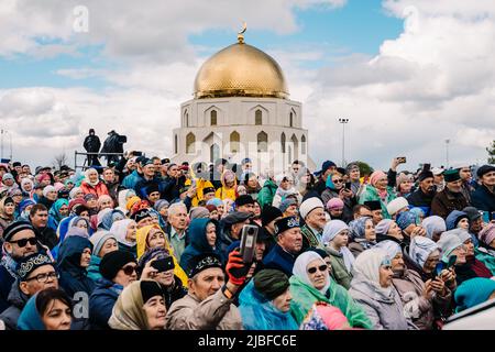 Bolgar, Tatarstan, Russland. 21.Mai 2022. Das Publikum beim Weihnachtskonzert. Eine Frau, die auf dem Smartphone ein Konzert schießt. Leute, die ein Konzert im Park unter freiem Himmel beobachten Stockfoto