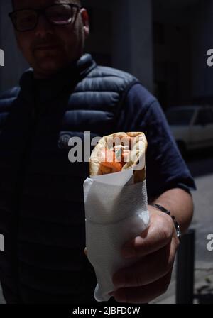 Athen, Griechenland. 4.. Juni 2022. Ein Mann hält das traditionelle Street Food „Souvlaki“, das er gerade von einem Restaurant gekauft hat. Der Preis für Griechenlands beliebtestes Street Food steigt in die Höhe, da die Inflation im Mai von 10,2 Prozent im April auf rund 10,7 Prozent gestiegen ist und damit den höchsten Stand seit 28 Jahren erreicht hat. (Bild: © Dimitris Aspiotis/Pacific Press über ZUMA Press Wire) Stockfoto