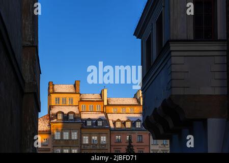 Historische Häuser mit verschneiten Dächern bei Sonnenuntergang in der Altstadt von Warschau in Polen. Stockfoto