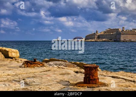Malta Island, altes Meer am Wasser mit rostigen Anlegestellen Poller in Sliema mit Blick über den Hafen Marsamxett bis Fort St Elmo in Valletta. Stockfoto