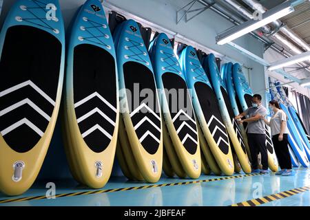 BINZHOU, CHINA - 6. JUNI 2022 - Ein Arbeiter produziert Surfbretter für Bestellungen aus dem Ausland in einer Surfbrett-Produktionswerkstatt in Binzhou, Shandong, Ostchina Stockfoto