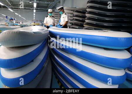 BINZHOU, CHINA - 6. JUNI 2022 - Ein Arbeiter produziert Surfbretter für Bestellungen aus dem Ausland in einer Surfbrett-Produktionswerkstatt in Binzhou, Shandong, Ostchina Stockfoto