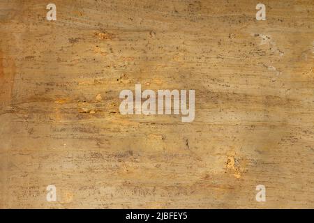 Gelbe, raue Natursteinstruktur mit orangefarbenen und braunen Adern Stockfoto