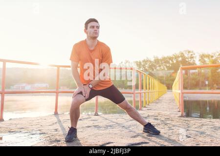 Fit Mann Aufwärmen dabei Ausfallschritte beim Training am Morgen laufen Stockfoto