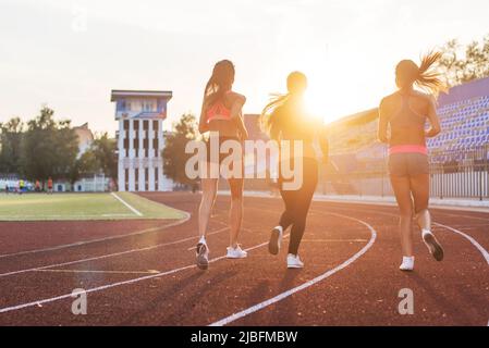 Rückansicht der Frauen, die im Stadion zusammen laufen Stockfoto
