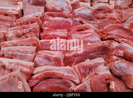 Hintergrund von frischem rohem, gehacktem Fleisch. Sortiment von Fleischfilets in einem Lebensmittelgeschäft. Stockfoto