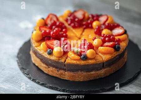 Dekorierte süße Orangenbeere und Obstkuchen Stockfoto