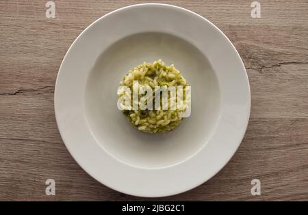 Italienisches Risotto mit Spargel. Cremiges Spargelrisotto auf Holzhintergrund. Stockfoto