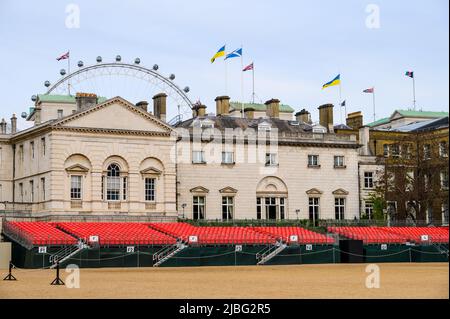 LONDON - 18. Mai 2022: Sitzplätze für das Platinum Jubilee Trooping of the Color-Fest bei der Horse Guards Parade mit London Eye im Hintergrund Stockfoto