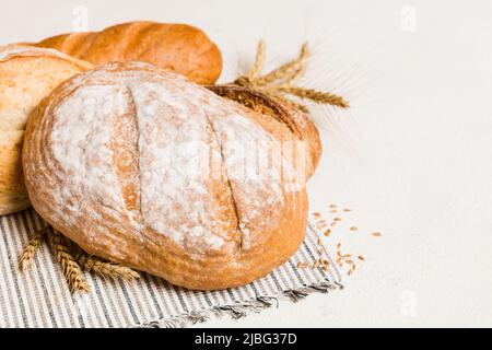 Hausgemachtes natürliches Brot. Verschiedene Arten von frischem Brot als Hintergrund, perspektivische Ansicht mit Kopierraum. Stockfoto