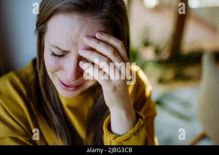 Frau, die an Depressionen leidet und zu Hause weint. Stockfoto
