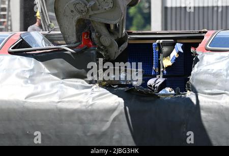 Garmisch Partenkirchen, Deutschland. 06.. Juni 2022. Ein Bagger trennt einen Wagen zur Demontage in zwei Teile. Drei Tage nach dem Zugunfall in Garmisch-Partenkirchen gehen die Sanierungsarbeiten voran. Quelle: Angelika Warmuth/dpa/Alamy Live News Stockfoto