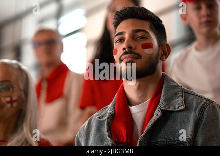 Begeisterte Fußballfans, die die Nationalmannschaft von Monaco bei einem Live-Fußballspiel im Stadion unterstützen. Stockfoto