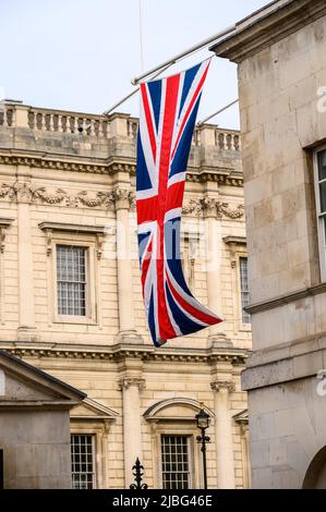 LONDON - 18. Mai 2022: Union Jack-Flagge hängt an klassischen Londoner Steingebäuden Stockfoto