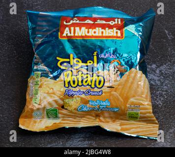 Eine Packung Al Mudhish Potato Ripples Crunch Chips, ein beliebter Snack in Oman, fotografiert auf einer dunklen strukturierten Oberfläche. Redaktionelle Verwendung nur durch Brandi Stockfoto
