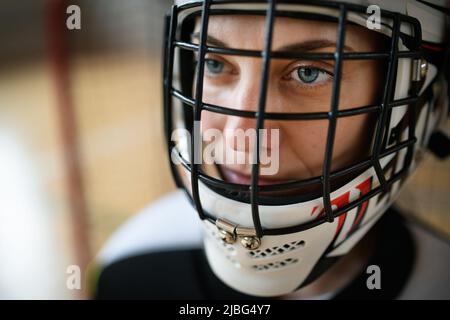 Nahaufnahme einer Unihockey-Torhüterin im Helmkonzept beim Spiel im Fitnessstudio. Stockfoto