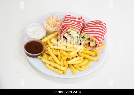 Yorkshire, Großbritannien – 18. März 2019: Köstliche knusprige Chicken Strips Wrap serviert mit Chips, Beilagen und Salat bei Dixy Chicken, Doncaster Stockfoto