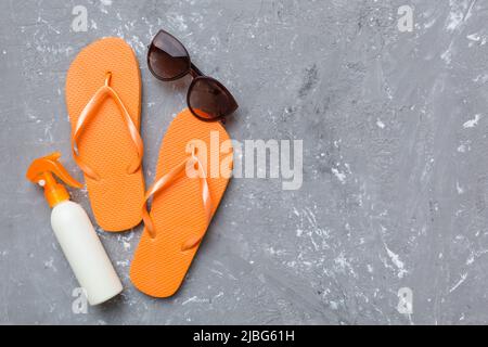 Reisekonzept für den Sommer. Flip Flops, Sonnenbrillen und Seesterne auf Weiß. Draufsicht auf farbigem Hintergrund. Stockfoto