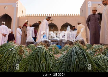 Eine Szene aus einem traditionellen Markt in Oman, auf dem sich Männer treffen, um frisches Futter und Kräuter zu handeln, wobei lokale landwirtschaftliche Praktiken und das Gemeinwesen vorgestellt werden Stockfoto