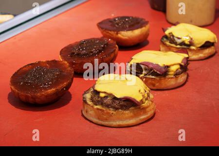 Burger, Hamburger oder Cheeseburger stehen an der Küchentheke des Restaurants bereit, um serviert zu werden. Stockfoto