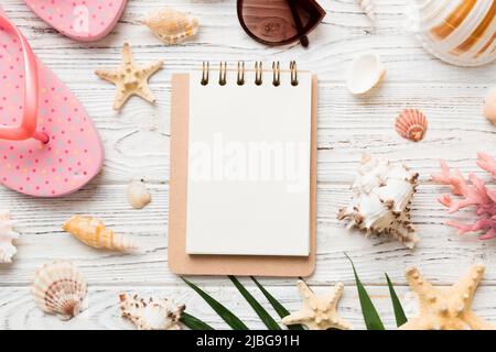 Leeres Schreibbuch mit Sommer-Strand-Accessoires auf Hintergrund, Kopierplatz. Flach liegend mit Kopierplatz. Stockfoto