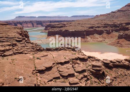 Der Colorado River schlängelt sich an einem sehr heißen, sonnigen Tag durch die Wüste von Utah. Rote Felsen und Sand in einem trockenen Land. River Canyon in der Wüste. Geologie der Amerikaner Stockfoto