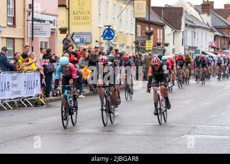 High Street, Hadleigh, Suffolk, Großbritannien. 6. Juni 2022. Das UCI Women’s Tour-Radrennen hat begonnen: Die besten Fahrer der Welt starten von Colchester zur Etappe 1 142km durch die Landschaft von Essex und Suffolk bis zum Ziel in Bury St. Edmunds. Eine Sprintstrecke endete in der High Street von Hadleigh im Regen, gewonnen von Maike van der Duin von Le Col Wahoo (links), vor Alison Jackson und Laura Tomasi. Zuschauer säumten die Straße, um die Fahrer durch die Stadt zu feuern Stockfoto