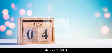 Niedlicher Holzkalender mit Datum vom 4. Juli auf blauem Himmel Hintergrund. Hintergrund zum US-Unabhängigkeitstag Stockfoto