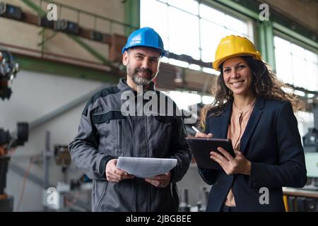 Ingenieurin und Mechanikerin, die Routineprüfung in der Industriefabrik macht Stockfoto