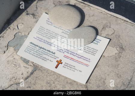 Kleines Papier mit georgischer Schrift über Religion und einem Kreuz darauf. Hochwertige Fotos Stockfoto