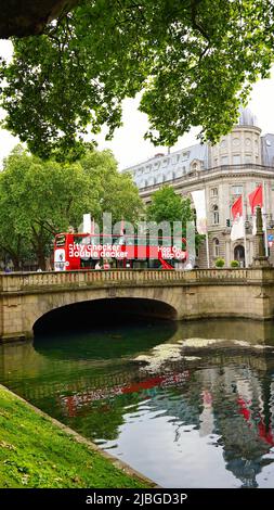 Rote Doppeldecker-Stadtrundfahrt 'Hop on / Hop off'-Bus auf einer Brücke über den Kö-Graben, den Stadtkanal an der Königsallee in Düsseldorf/Deutschland. Stockfoto