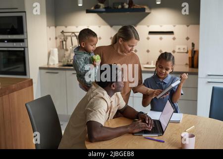 Porträt der multiethnischen Familie mit zwei Kindern in häuslichen Interieur schwarz und kaukasischen Elternpaar Stockfoto