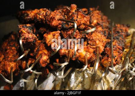 Auf einem Metallspieß gegartes Set von gegrillten Kebabs. BBQ frisches Hähnchenfleisch hacken Scheiben. Grill auf Holzkohle und Flamme, die leckere Street Food ist Stockfoto