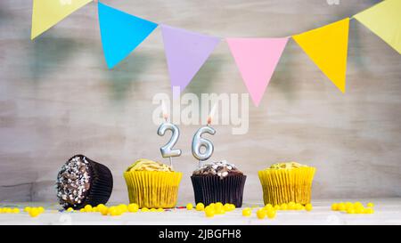 Geburtstag Hintergrund mit Nummer. Wunderschöne Geburtstagskarte mit bunten Girlanden, einem Muffin mit einem Kerzenbrenner-Copyspace. Stockfoto