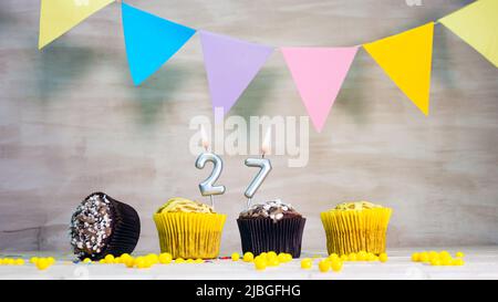 Geburtstag Hintergrund mit Nummer. Wunderschöne Geburtstagskarte mit bunten Girlanden, einem Muffin mit einem Kerzenbrenner-Copyspace. Stockfoto