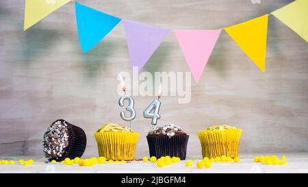 Geburtstag Hintergrund mit Nummer. Wunderschöne Geburtstagskarte mit bunten Girlanden, einem Muffin mit einem Kerzenbrenner-Copyspace. Stockfoto