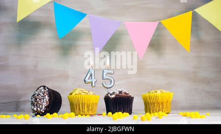 Geburtstag Hintergrund mit Nummer. Wunderschöne Geburtstagskarte mit bunten Girlanden, einem Muffin mit einem Kerzenbrenner-Copyspace. Stockfoto