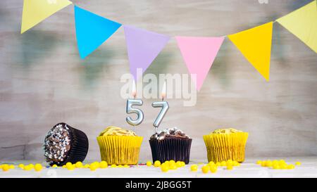 Geburtstag Hintergrund mit Nummer. Wunderschöne Geburtstagskarte mit bunten Girlanden, einem Muffin mit einem Kerzenbrenner-Copyspace. Stockfoto