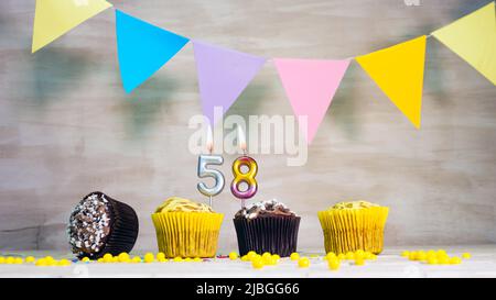 Geburtstag Hintergrund mit Nummer. Wunderschöne Geburtstagskarte mit bunten Girlanden, einem Muffin mit einem Kerzenbrenner-Copyspace. Stockfoto