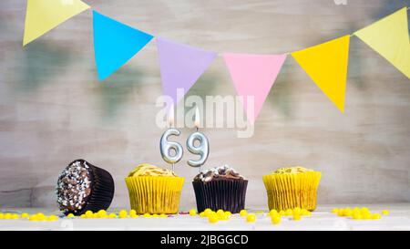 Geburtstag Hintergrund mit Nummer. Wunderschöne Geburtstagskarte mit bunten Girlanden, einem Muffin mit einem Kerzenbrenner-Copyspace. Stockfoto