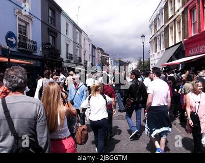 Menschen, die in Notting Hill auf der Hauptstraße laufen. Notting Hill ist ein wohlhabender Stadtteil von West London im Royal Borough of Kensington and Chelsea Stockfoto