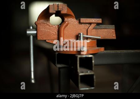 Befestigungselemente in der Werkstatt. Halter für Teile. Werkzeug zum Zusammendrücken des Werkstücks. Vorschlaghammer aus Stahl. Stockfoto