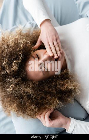 Draufsicht auf die erwachte Frau, die morgens gähnte und den Mund mit der Hand bedeckte Stockfoto