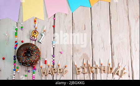 Geburtstag mit Nummer. Donut auf dem Festtisch. Alles gute zum Geburtstag, herzlichen Glückwunsch, Draufsicht. Happy Birthday Karte mit schönen Dekorationen auf einem weißen Stockfoto