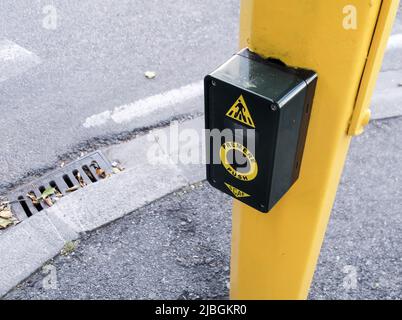 Firenzano, Italien - 23. Juni 2011 : Gelber Pol mit Ampelknopf für den Fußgängerüberweg mit SCAE in italienischer Sprache. Übersetzung: Presse Stockfoto